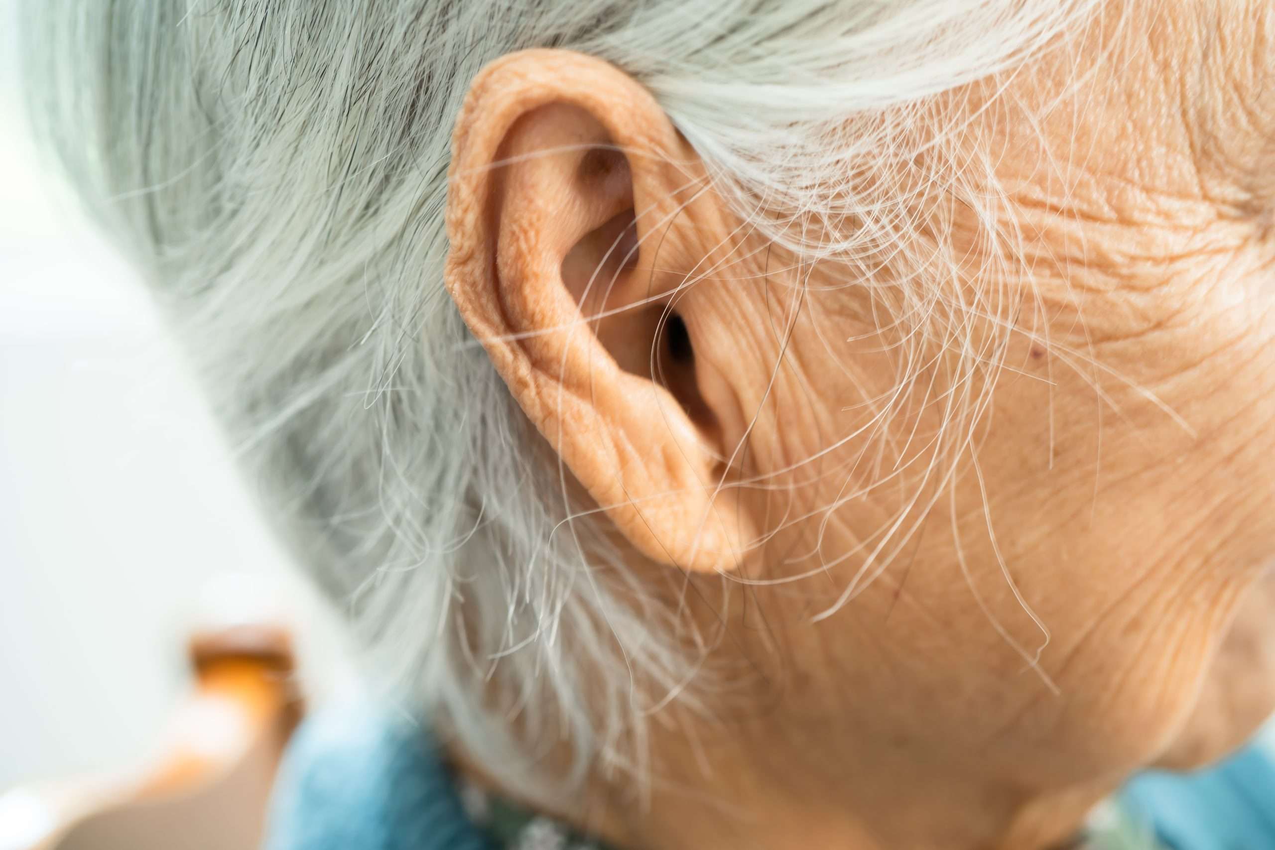 Ear of Asian senior woman, listening or hearing loss problem.